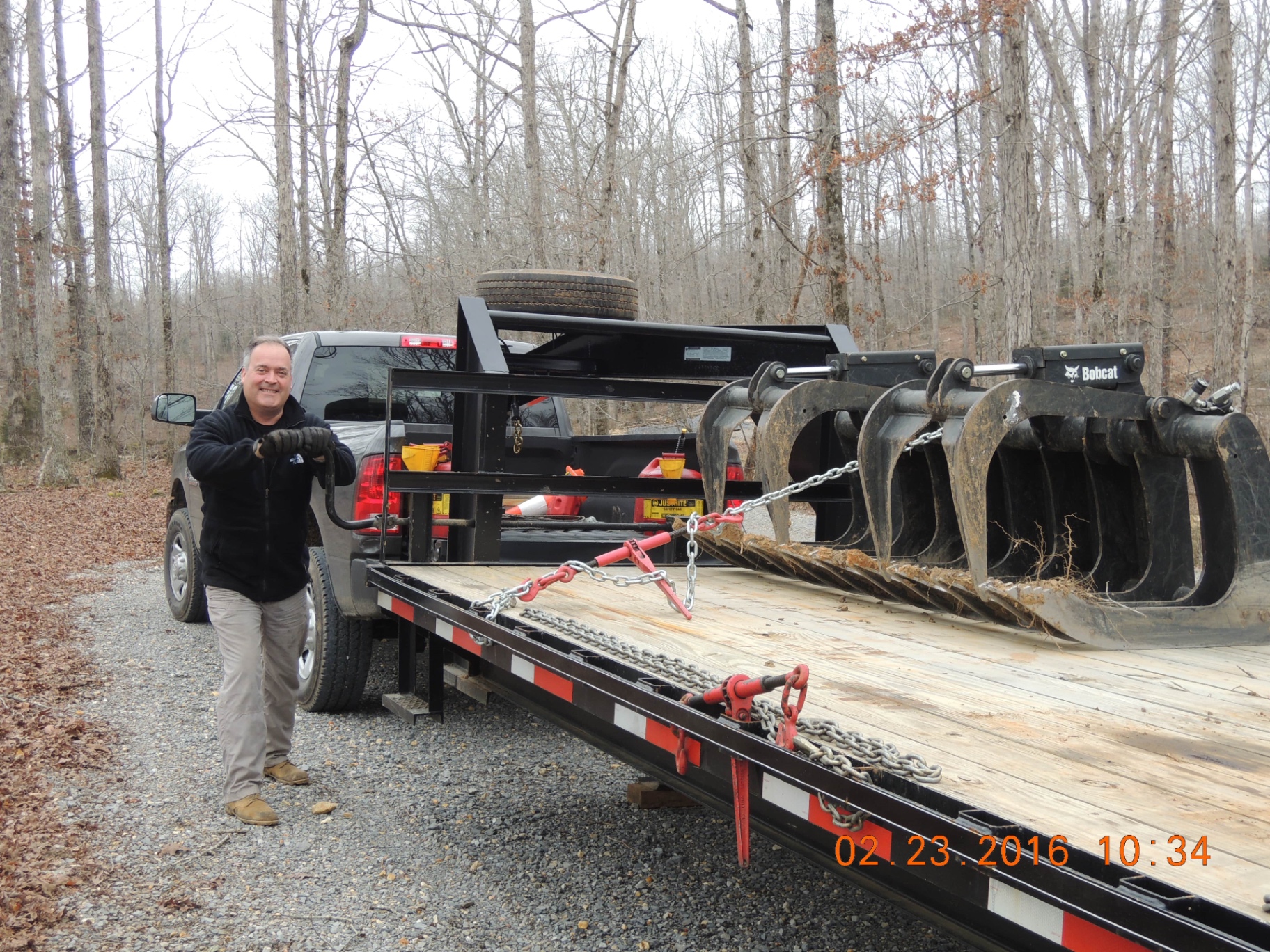 TRUEHOUR founder Dave Clevinger with work truck, trailer, and grapple attachment at a forestry mulching job site in 2016.